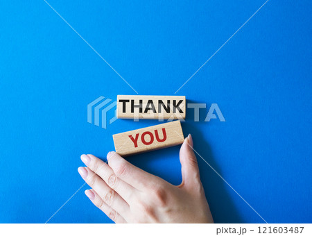 Thank you symbol. Wooden blocks with words Thank you. Businessman hand. Beautiful blue background. Business and Thank you concept. Copy space. Thank you symbol. Wooden blocks with words Thank you. Businessman hand. Beautiful blue background. Business and Thank you concept. Copy space. 121603487