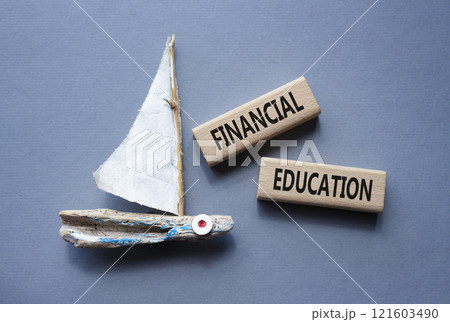 Financial Education symbol. Concept word Financial Education on wooden blocks. Beautiful grey background with boat. Business and Financial Education concept. Copy space 121603490
