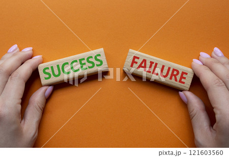 Success or Failure symbol. Concept word Success or Failure on wooden blocks. Businessman hand. Beautiful orange background. Business and Success or Failure concept. Copy space Success or Failure symbol. Concept word Success or Failure on wooden blocks. Businessman hand. Beautiful orange background. Business and Success or Failure concept. Copy space 121603560