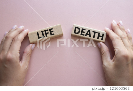Life or Death symbol. Concept word Life or Death on wooden blocks. Businessman hand. Beautiful pink background. Business and Life or Death concept. Copy space Life or Death symbol. Concept word Life or Death on wooden blocks. Businessman hand. Beautiful pink background. Business and Life or Death concept. Copy space 121603562