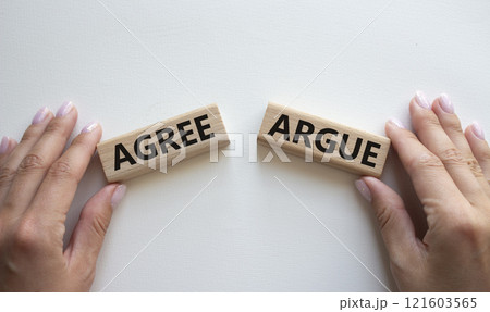 Agree or Argue symbol. Concept word Agree or Argue on wooden blocks. Businessman hand. Beautiful white background. Gender and Agree or Argue concept. Copy space 121603565