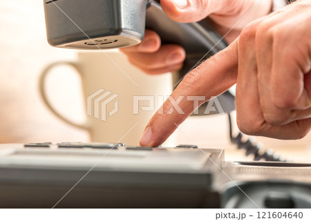 Close up Index Finger Dialing on Black Telephone 121604640