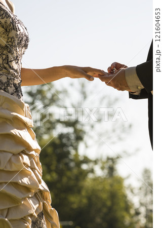 Closeup of groom placing a wedding ring on his brides finger Closeup of groom placing a wedding ring on his brides finger 121604653