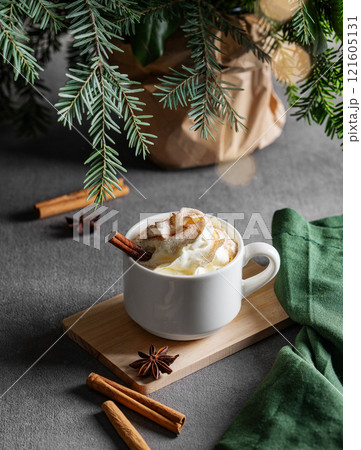 White mug with hot chocolate with whipped cream, cinnamon and anise on a wooden board White mug with hot chocolate with whipped cream, cinnamon and anise on a wooden board 121605131