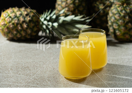 Pineapple juice in glasses among fresh pineapples. 121605172