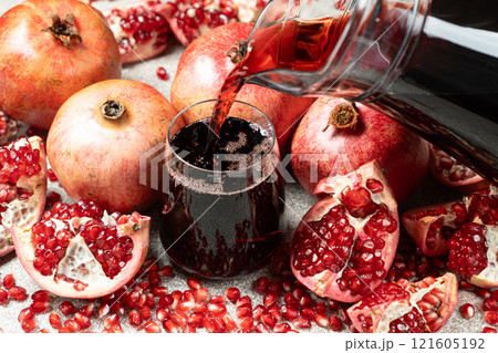 Pomegranate juice pouring from jug into glass Pomegranate juice pouring from jug into glass 121605192