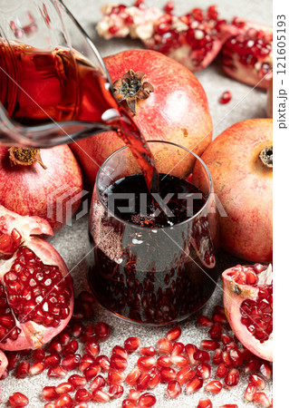 Pomegranate juice pouring from jug into glass Pomegranate juice pouring from jug into glass 121605193