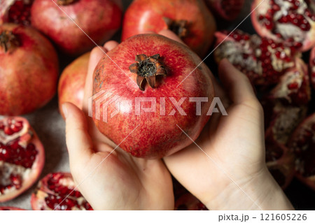 Ripe pomegranate in the hands, the concept of benefits and vitamins. Ripe pomegranate in the hands, the concept of benefits and vitamins. 121605226