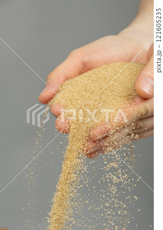 Hands pour crystalline cane brown unrefined healthy demerara sugar Hands pour crystalline cane brown unrefined healthy demerara sugar 121605235