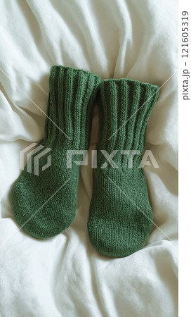 Photorealistic mockup showcasing a cozy pair of green socks on a soft white fabric 121605319