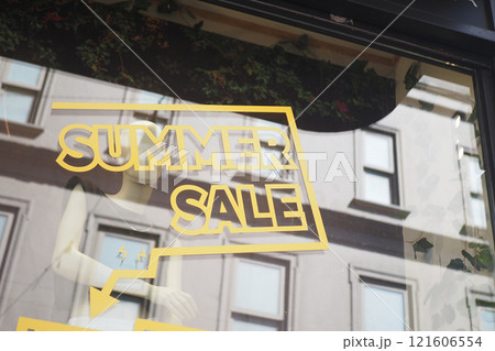 Large yellow Sale text letters on a glass wall obstruct a view inside the popular fashion store 121606554