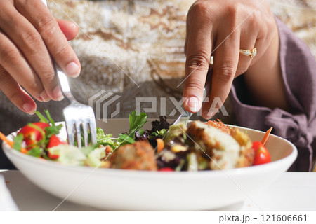 A Detailed CloseUp of a Hand Skillfully Preparing a Fresh Salad Meal A Detailed CloseUp of a Hand Skillfully Preparing a Fresh Salad Meal 121606661