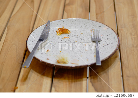 An empty dirty plate with a fork. 121606687