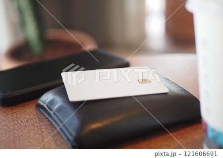 A minimalistic wallet and a card placed neatly on a table surface A minimalistic wallet and a card placed neatly on a table surface 121606691