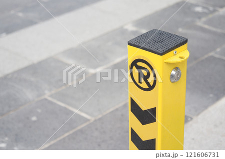 Yellow No Parking Post With Arrows On Paved Urban Street 121606731