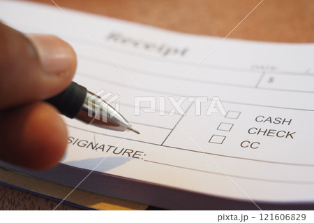 Signing the Receipt by Hand Using a Pen on the Payment Form Provided 121606829