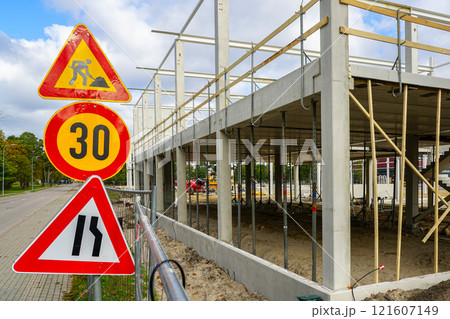 Unfinished concrete and metal structure building frame with traffic restriction warning signs Unfinished concrete and metal structure building frame with traffic restriction warning signs 121607149