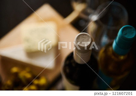 Wine and cheese pairing setup on a wooden board with glasses Wine and cheese pairing setup on a wooden board with glasses 121607201