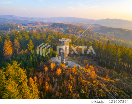 The Cisarsky Kamen wooden lookout tower near Liberec stands tall amidst vibrant autumn foliage as a stunning sunset paints the sky in warm hues. Nature's beauty is on full display. The Cisarsky Kamen wooden lookout tower near Liberec stands tall amidst vibrant autumn foliage as a stunning sunset paints the sky in warm hues. Nature's beauty is on full display. 121607894