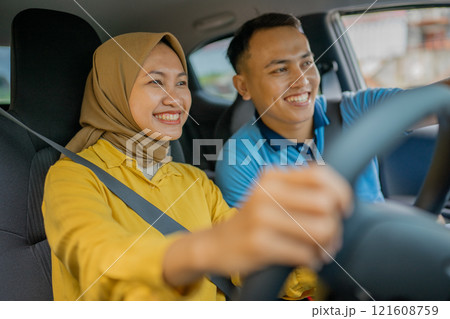 A Joyful Young Couple Happily Enjoying a Scenic Drive Together in Their Car A Joyful Young Couple Happily Enjoying a Scenic Drive Together in Their Car 121608759