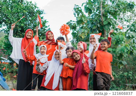 happy young girls and boys holding small Indonesian flags during celebration happy young girls and boys holding small Indonesian flags during celebration 121608837