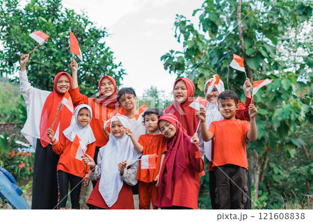 young girls in headscarves and smiling boys holding small Indonesian flags young girls in headscarves and smiling boys holding small Indonesian flags 121608838