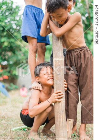 a child squats on a friend's step as a fulcrum a child squats on a friend's step as a fulcrum 121608854