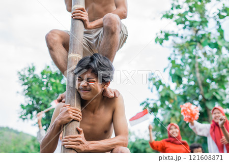 man enduring the load takes part in a betel nut climbing competition man enduring the load takes part in a betel nut climbing competition 121608871
