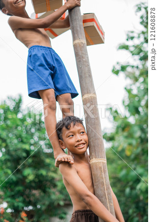 a boy laughs easily when a friend stands on his shoulder a boy laughs easily when a friend stands on his shoulder 121608878