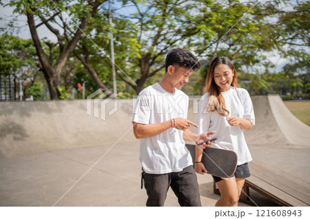 A Group of Youthful Friends Enjoying Their Time Together at a Skate Park 121608943