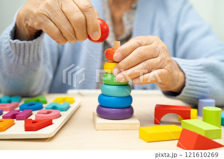 Alzheimer disease AD, Asian elderly woman patient suffering from dementia learn practical motor skills rehabilitation. Alzheimer disease AD, Asian elderly woman patient suffering from dementia learn practical motor skills rehabilitation. 121610269