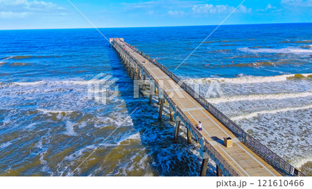 A Beautiful Scenic Wooden Pier Stretching Out Over the Ocean Waves 121610466