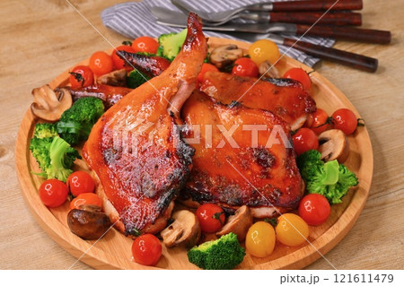 クリスマス用の手作りのローストチキン、ローストレッグ、クリスマスチキン、骨つき鶏モモ肉の照り焼き。 クリスマス用の手作りのローストチキン、ローストレッグ、クリスマスチキン、骨つき鶏モモ肉の照り焼き。 121611479