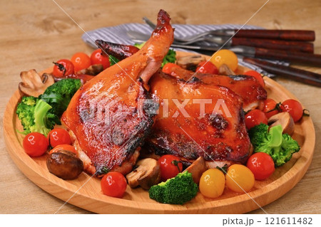 クリスマス用の手作りのローストチキン、ローストレッグ、クリスマスチキン、骨つき鶏モモ肉の照り焼き。 クリスマス用の手作りのローストチキン、ローストレッグ、クリスマスチキン、骨つき鶏モモ肉の照り焼き。 121611482