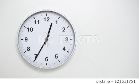 Minimalist White Clock with Silver Frame Striking 12.35/00.35 on White Background. Perfect for Time Management and Corporate Campaigns 121611751