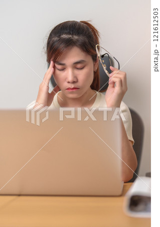 Stressed and Tired Asian woman while working, female businesswoman using laptop with headache, Migraine and Sleepy at office, Exhausted woman with computer at home late night. Overload and Overworked Stressed and Tired Asian woman while working, female businesswoman using laptop with headache, Migraine and Sleepy at office, Exhausted woman with computer at home late night. Overload and Overworked 121612503