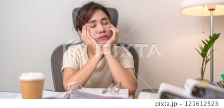 Stressed Asian woman having Tired and Sleepy while working, female businesswoman having headache at office, Exhausted woman with documents folder stack at home late night. Overworked and Overtime 121612523
