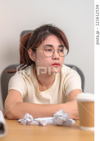 Stressed Asian woman having Tired and Sleepy while working, female businesswoman having headache at office, Exhausted woman with documents folder stack at home late night. Overworked and Overtime Stressed Asian woman having Tired and Sleepy while working, female businesswoman having headache at office, Exhausted woman with documents folder stack at home late night. Overworked and Overtime 121612539