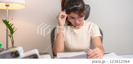 Asian woman having Tired and Stressed while working, female businesswoman having headache and Migraine at office, Exhausted woman with document folder stack at home late night. Overworked and Overtime Asian woman having Tired and Stressed while working, female businesswoman having headache and Migraine at office, Exhausted woman with document folder stack at home late night. Overworked and Overtime 121612564