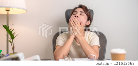 Stressed Asian woman having Tired and Sleepy while working, female businesswoman having headache at office, Exhausted woman with documents folder stack at home late night. Overworked and Overtime Stressed Asian woman having Tired and Sleepy while working, female businesswoman having headache at office, Exhausted woman with documents folder stack at home late night. Overworked and Overtime 121612568