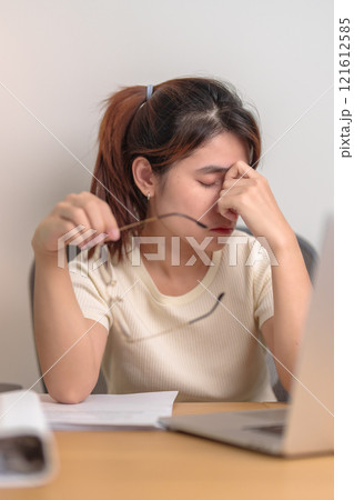 Stressed Asian woman having Tired and Sleepy while working, female businesswoman using laptop with headache at office, Exhausted woman with computer at home late night. Overload and Overworked Stressed Asian woman having Tired and Sleepy while working, female businesswoman using laptop with headache at office, Exhausted woman with computer at home late night. Overload and Overworked 121612585
