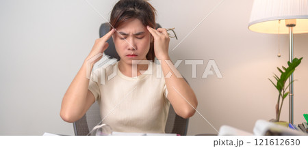female businesswoman having headache and Migraine at office, Asian woman having Tired and Stressed while working, Exhausted woman with document folder stack at home late night. Overworked and Overtime 121612630