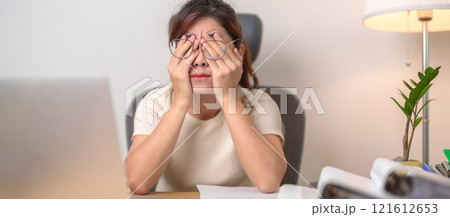 Stressed Asian woman having Tired and Sleepy while working, female businesswoman using laptop with headache at office, Exhausted woman with computer at home late night. Overload and Overworked 121612653