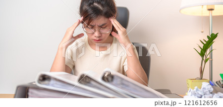 female businesswoman having headache and Migraine at office, Asian woman having Tired and Stressed while working, Exhausted woman with document folder stack at home late night. Overworked and Overtime female businesswoman having headache and Migraine at office, Asian woman having Tired and Stressed while working, Exhausted woman with document folder stack at home late night. Overworked and Overtime 121612656