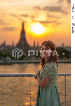tourist woman enjoys view to Wat Arun Temple in sunset, Traveler visits Temple of Dawn near Chao Phraya river from rooftop bar. Landmark and Travel destination in Bangkok, Thailand and Southeast Asia tourist woman enjoys view to Wat Arun Temple in sunset, Traveler visits Temple of Dawn near Chao Phraya river from rooftop bar. Landmark and Travel destination in Bangkok, Thailand and Southeast Asia 121612827