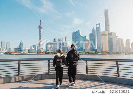 Couple traveler visiting in Shanghai, China. Tourists sightseeing Shanghai view of Lujiazui on The Bund of Shanghai. landmark and popular for tourism attractions. Vacation concept 121613021