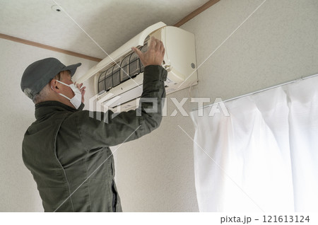 エアコンの清掃をするハウスクリーニングの男性作業員 121613124