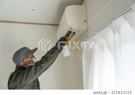 エアコンの清掃をするハウスクリーニングの男性作業員 エアコンの清掃をするハウスクリーニングの男性作業員 121613153