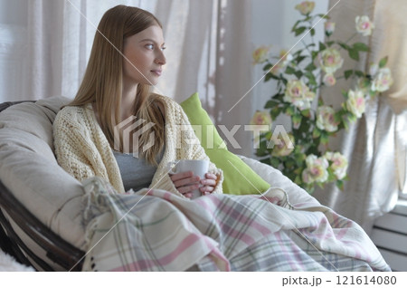 Portrait of young woman in pajamas on bed with fluffy plaid Portrait of young woman in pajamas on bed with fluffy plaid 121614080