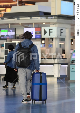 空港でスーツケースを引く旅行者　カートに荷物を積んで移動する旅行者 121615458